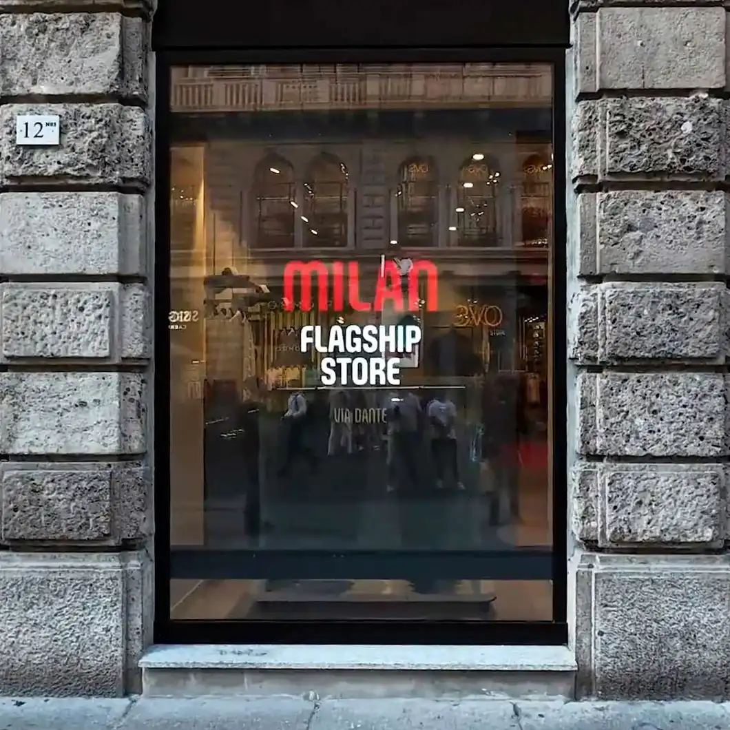 Entrance of AC Milan store with large LED screens showing team highlights.