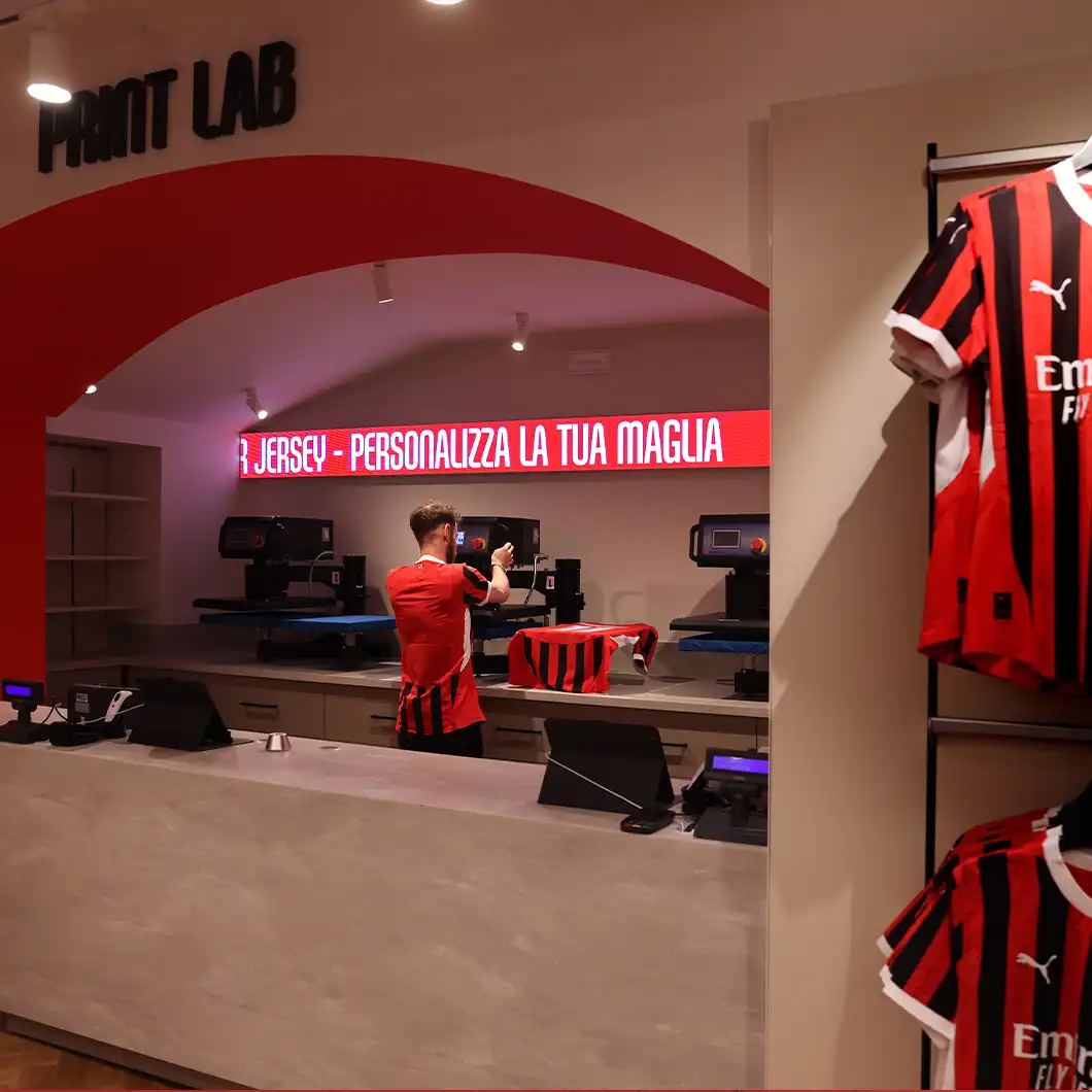 First floor of AC Milan store with multiple LED and LCD displays showing interactive content.