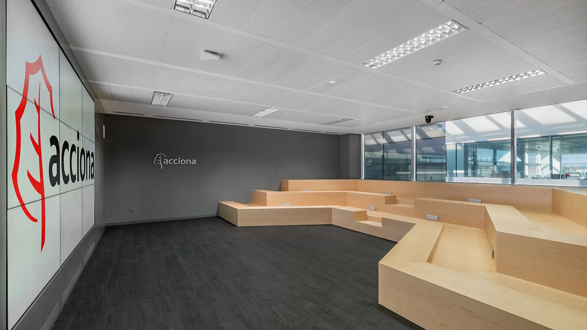 Employees using Acciona’s Agora Room for a corporate presentation with LED wall and surround sound integration by TRISON.