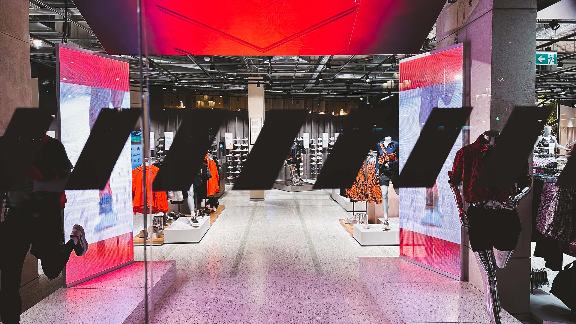 Dos paneles LED verticales enmarcando el corredor de entrada de la flagship de adidas en Barcelona, integrados por TRISON Germany