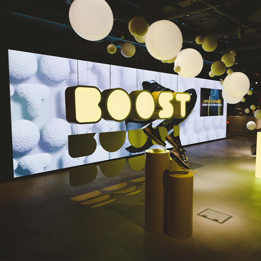 Boost zone LED wall with suspended sphere installation and product display pedestals in the adidas London flagship