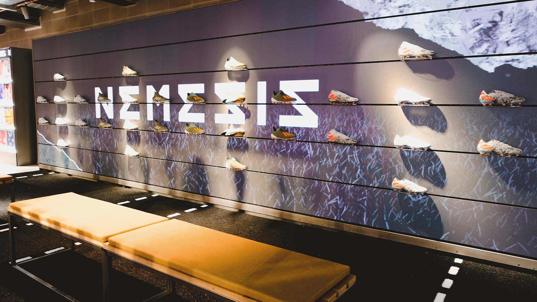 Large-format LED wall integrated behind a sneaker product display rail in the adidas London flagship store