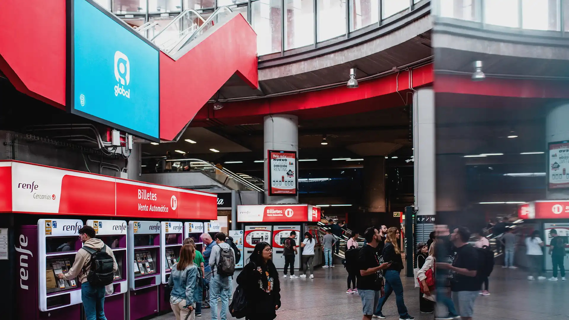 LED-Display in der Haupthalle des Atocha-Bahnhofs, das sich nahtlos in die klassische Architektur einfügt.