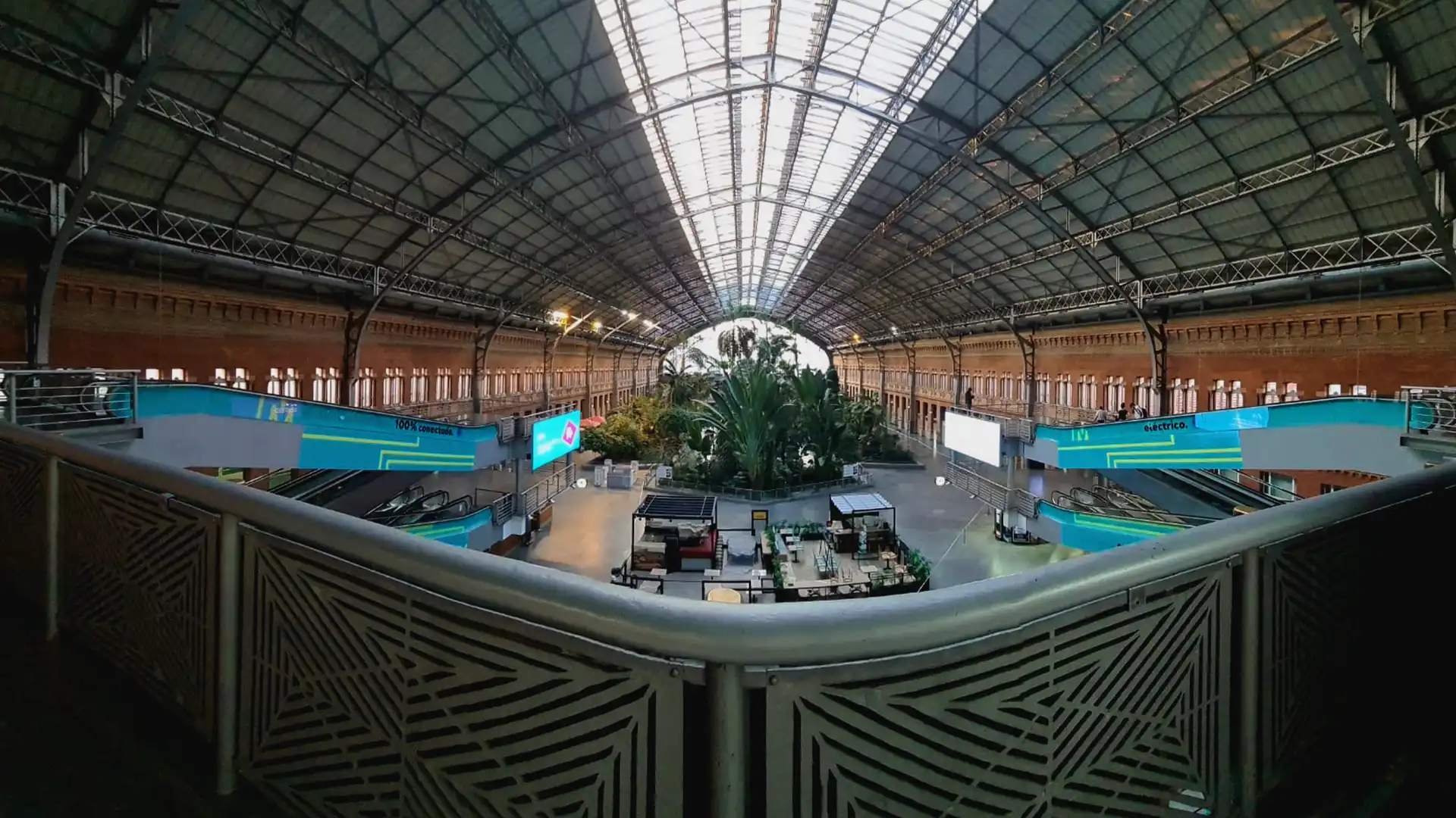 Reisende, die durch die zentrale Halle des Atocha-Bahnhofs gehen, sehen eine LED-Beschilderung mit dynamischen Inhalten.