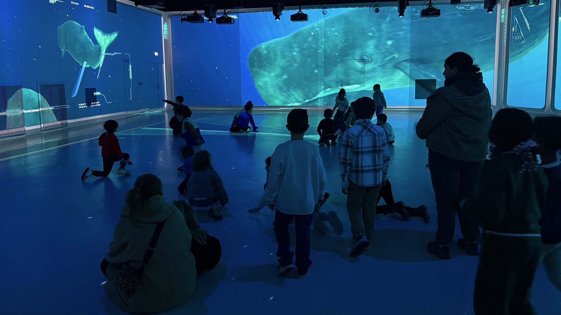 Children exploring the Ocean 360 immersive projection room with sperm whale imagery at Aquarium de Lyon, France