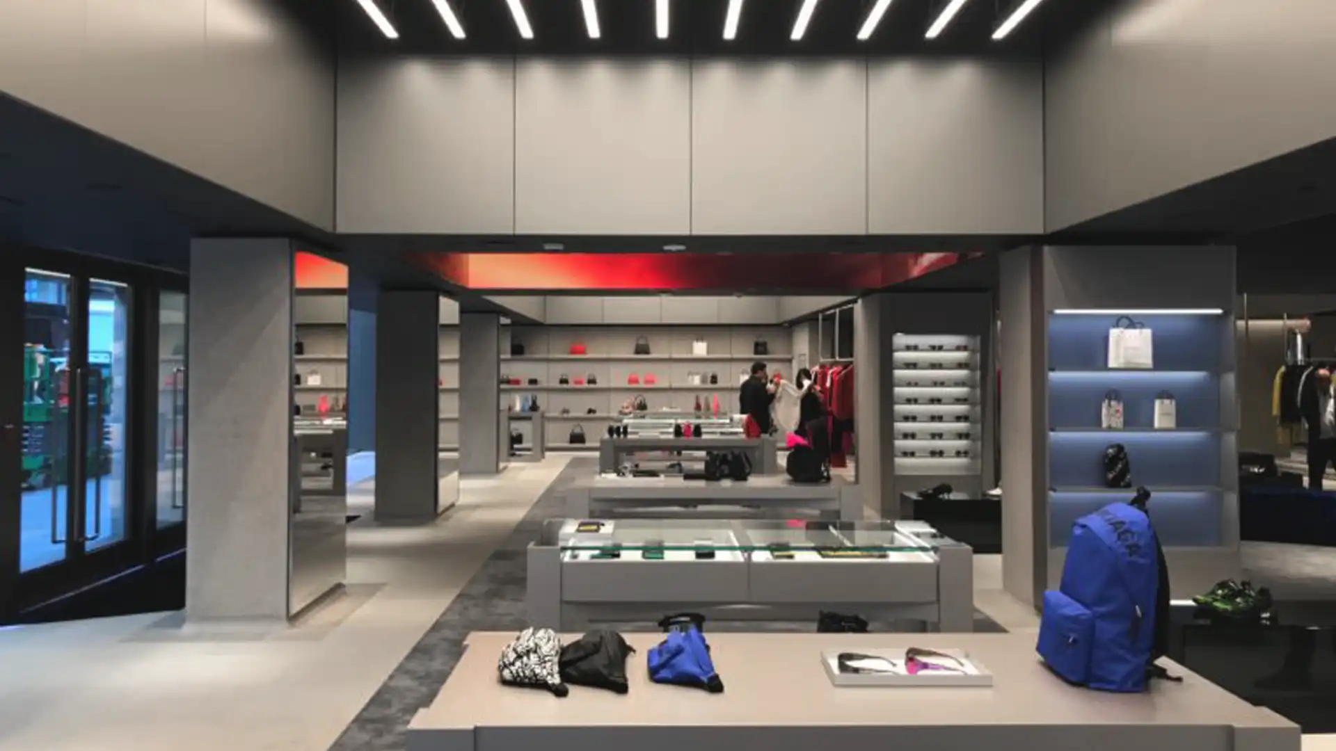 Clientes interactuando en el entorno digital inmersivo de Balenciaga, con superficies LED y una arquitectura refinada.