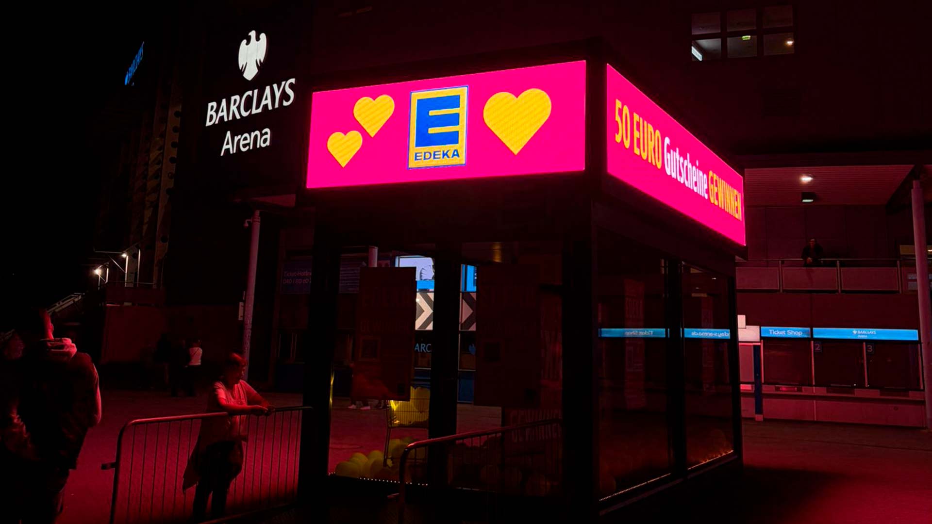 Cube LED BrandBox à quatre faces sur le Vorplatz de la Barclays Arena, intégré dans le parcours visiteur