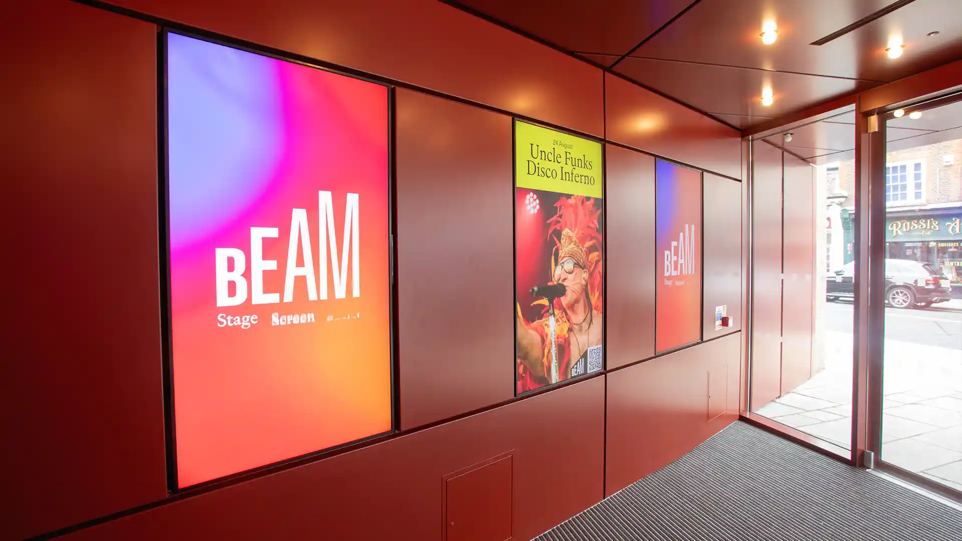Vue intérieure du Beam Theatre montrant le hall d'entrée rénové avec affichage numérique.