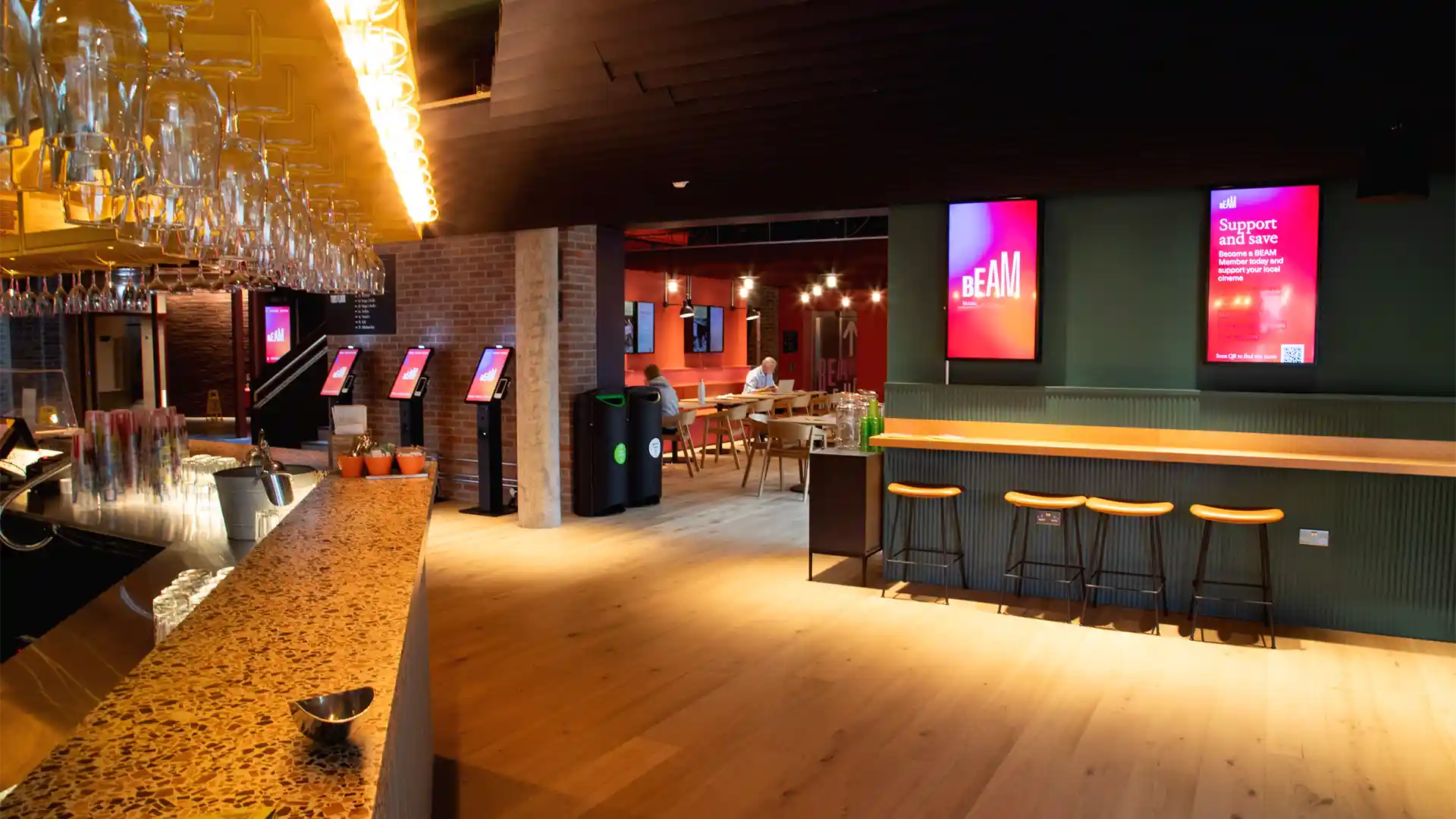 Vue extérieure de l'entrée rénovée du Beam Theatre avec signalisation numérique LED intégrée.