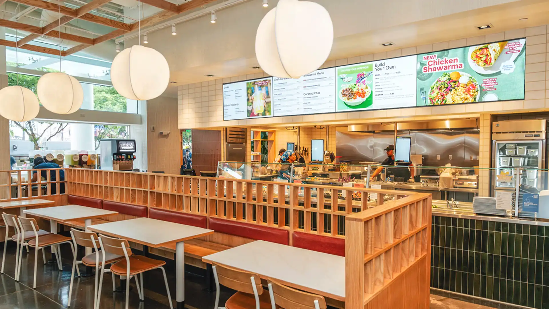 Interior of a CAVA restaurant in the USA showing TRISON North America’s digital menu displays and Mediterranean-inspired design.