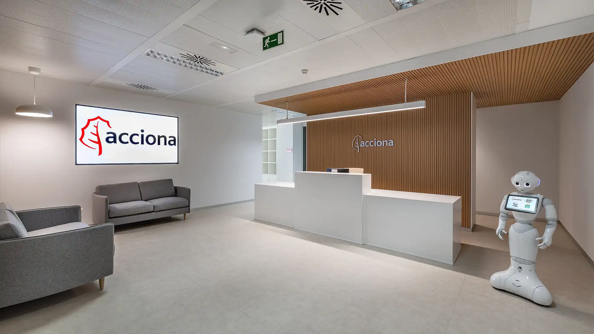 Reception area of Acciona’s offices in Madrid featuring digital signage screens and sustainable architecture integrated by TRISON.