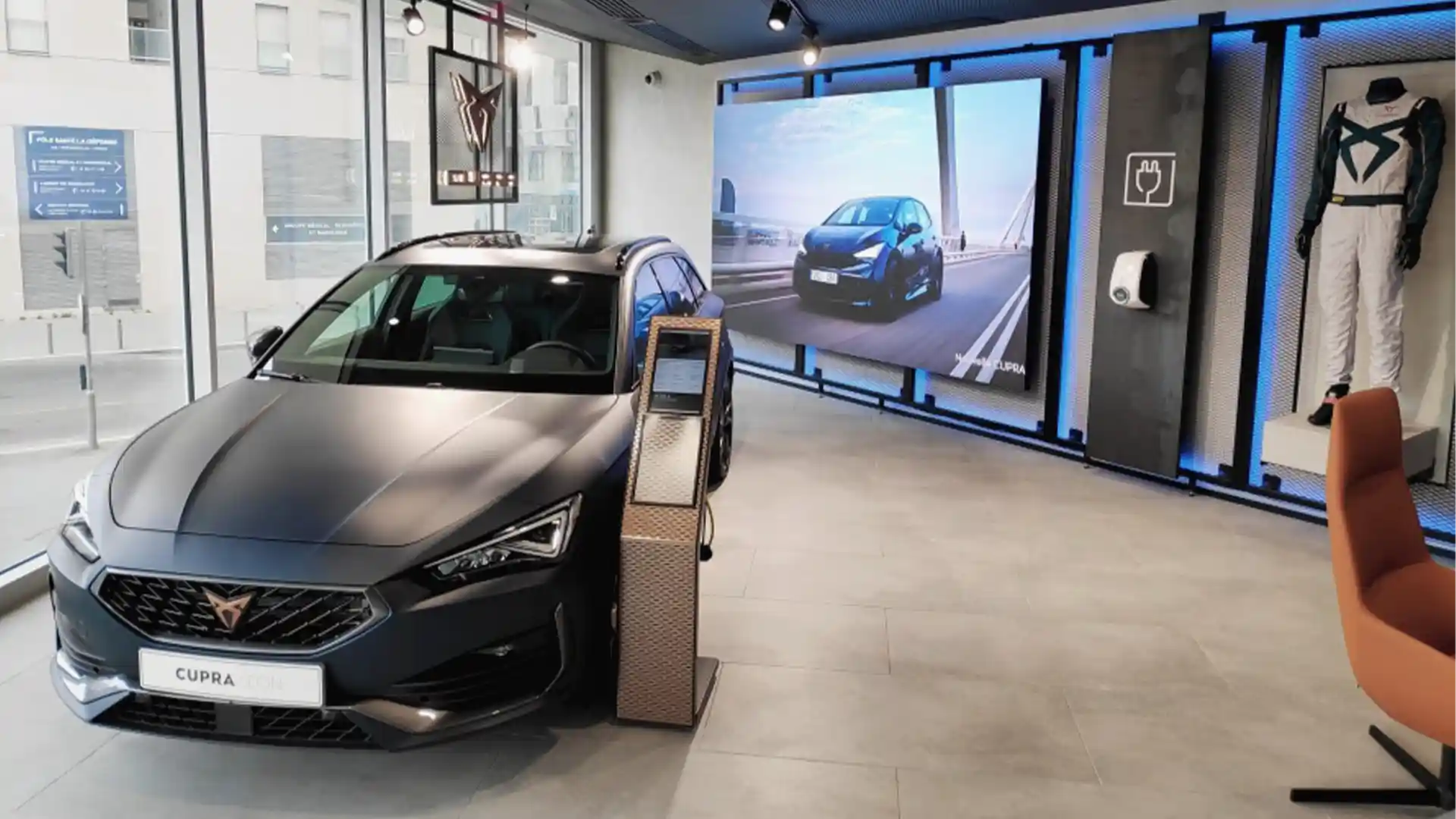 Vue extérieure de la CUPRA City Garage Paris avec écran LED et visuels immersifs de la marque.