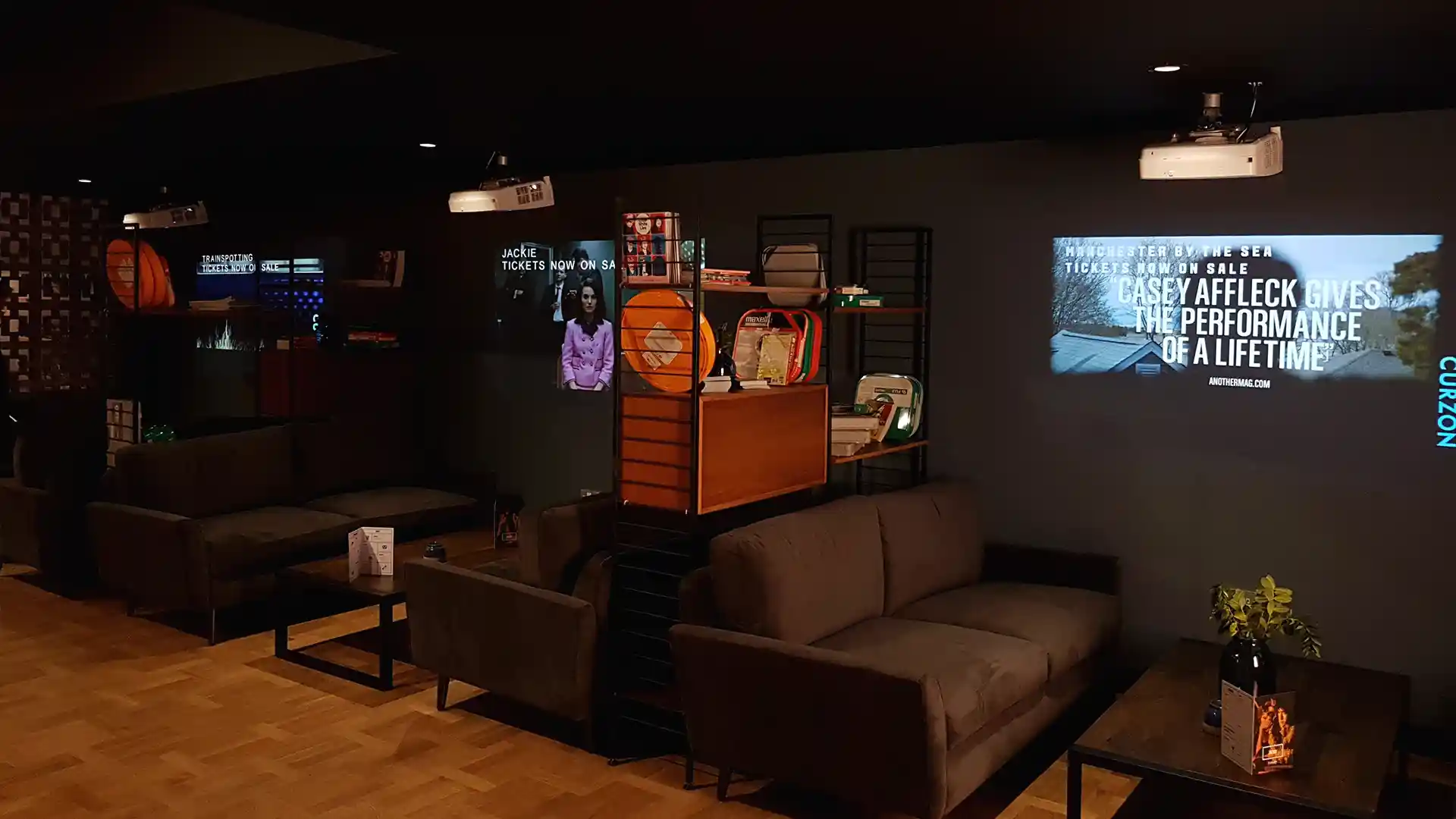 Cartelería digital de alto brillo en la entrada de un cine Curzon que atrae a los transeúntes.