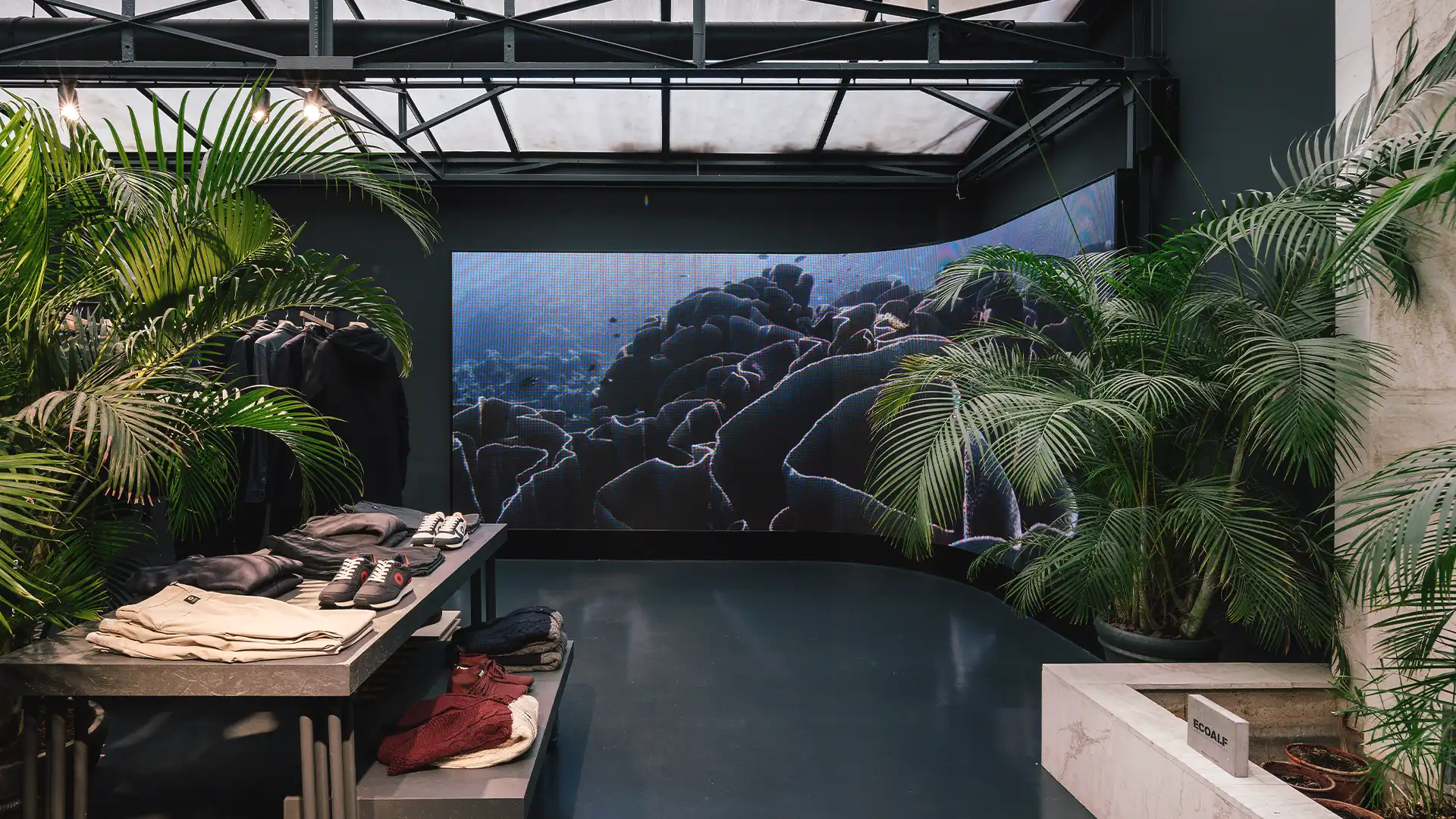 L'écran LED incurvé du magasin phare d'Ecoalf Madrid met en valeur le contenu environnemental.