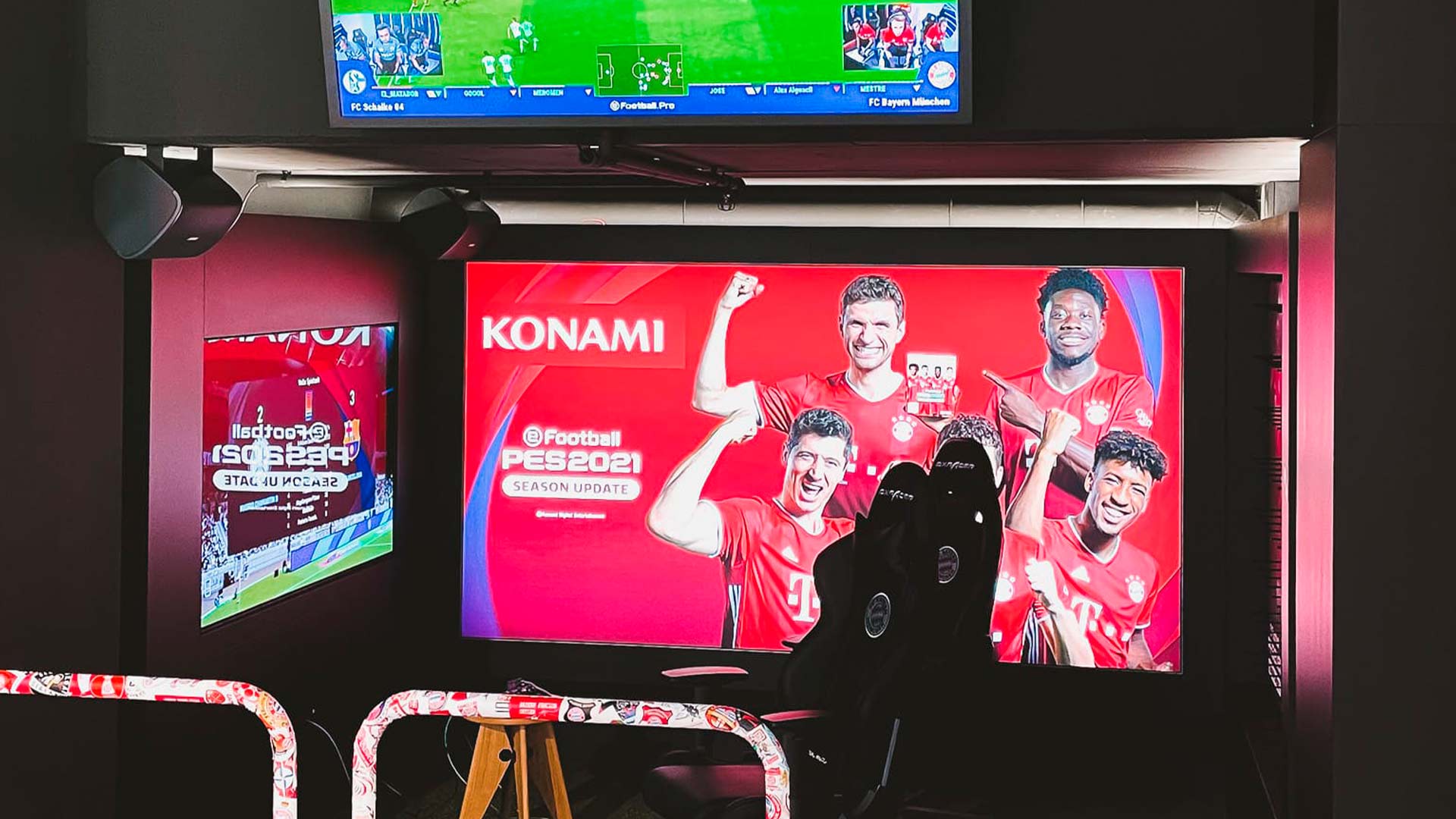 Gaming zone with football simulation screens and racing chair at FC Bayern World flagship store in Munich