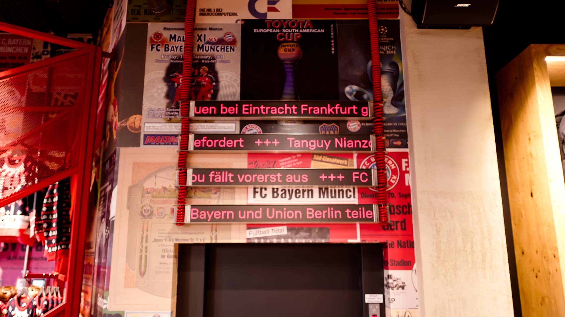 LED ticker displays embedded in FC Bayern match programme wall at FCBayern World Munich store