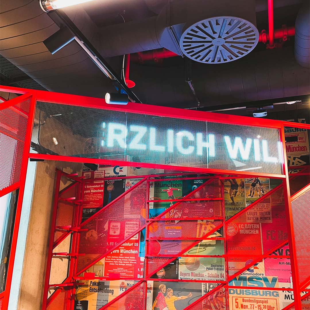 Full-height transparent LED display showing Adidas FC Bayern campaign content at FCBayern World Munich