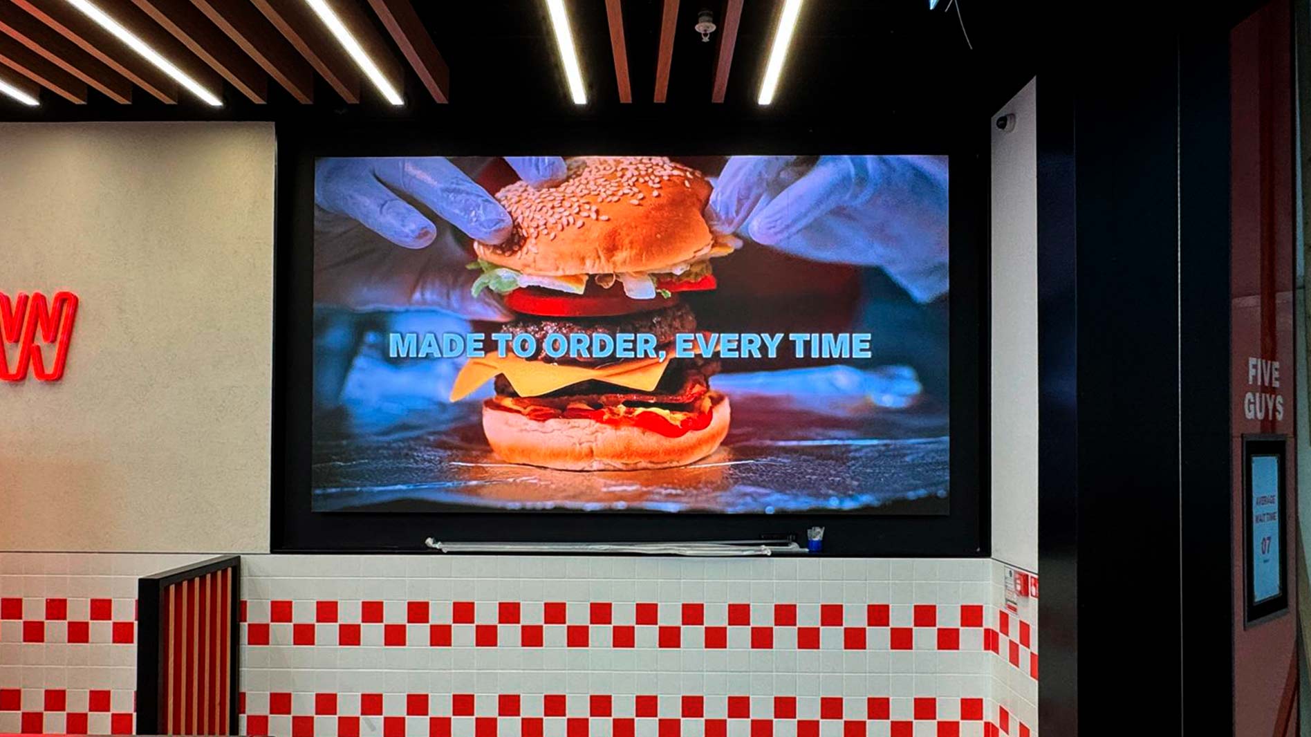 Pantalla LED de gran formato con contenido Five Guys en la Terminal 5 de Heathrow, instalada por TRISON