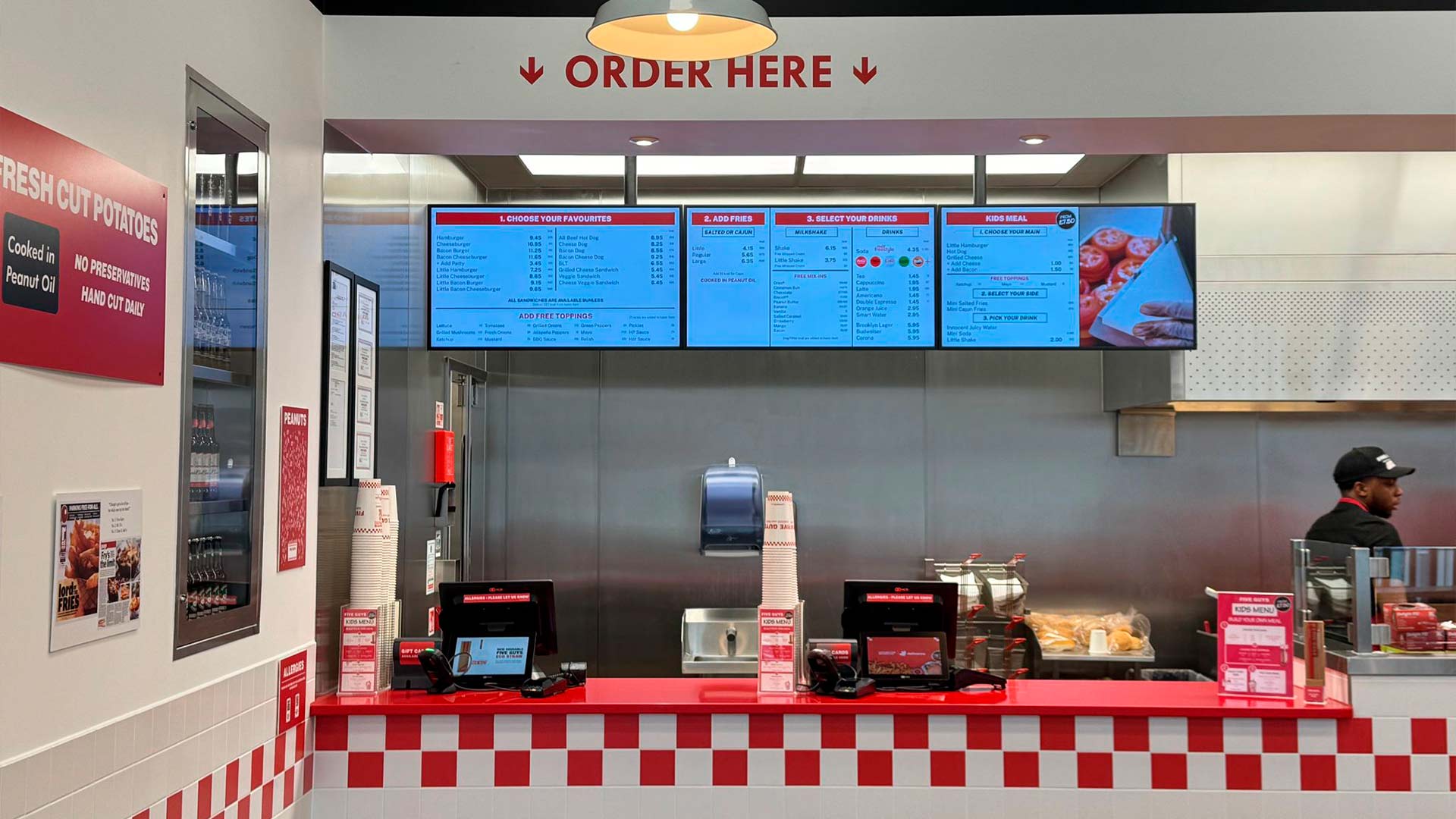 Triple pantalla de menú digital instalada por TRISON en el mostrador del restaurante Five Guys de Leamington Spa