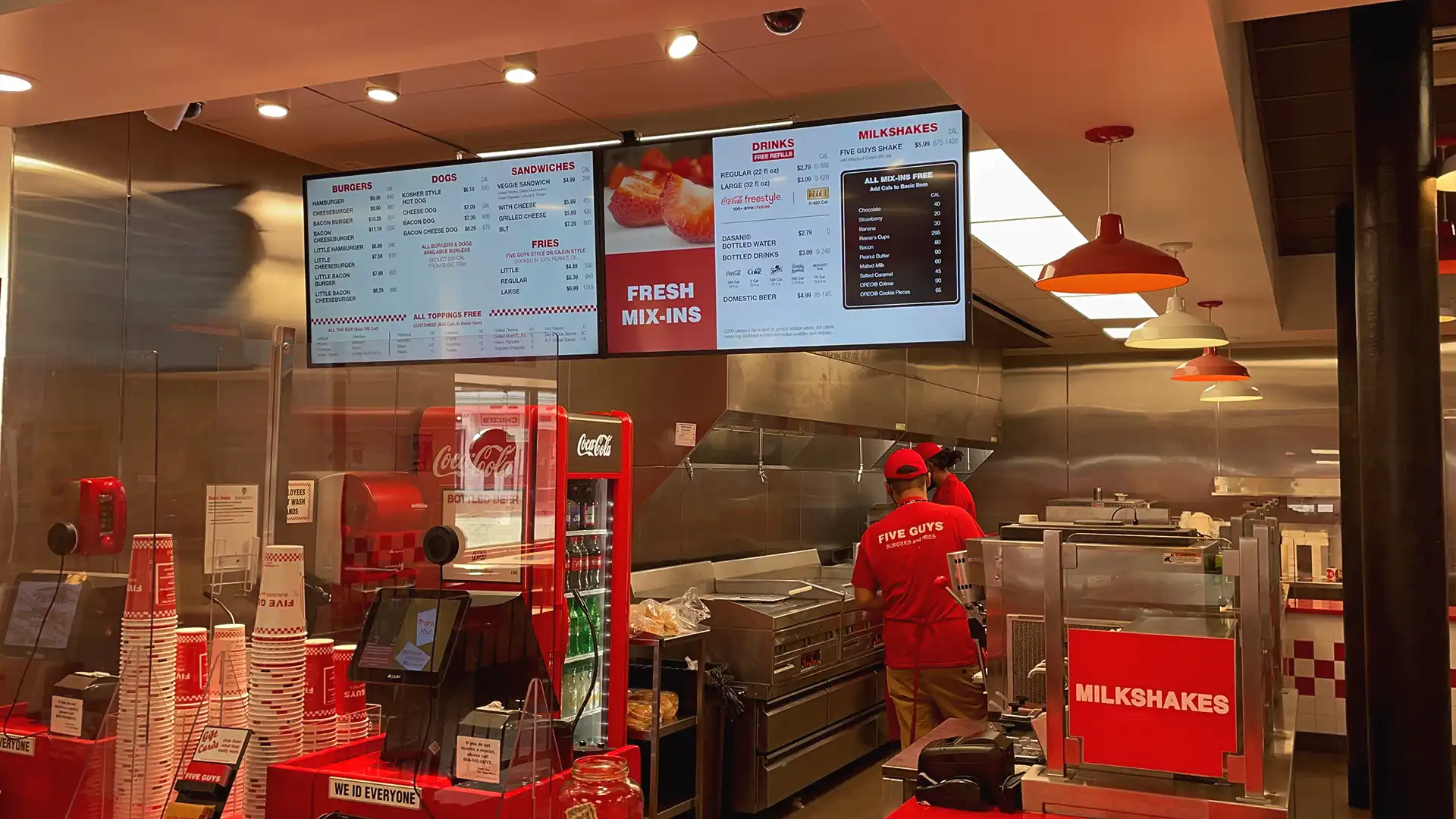Interior of Five Guys restaurant in the USA featuring digital menu boards and TRISON North America’s audiovisual integration.