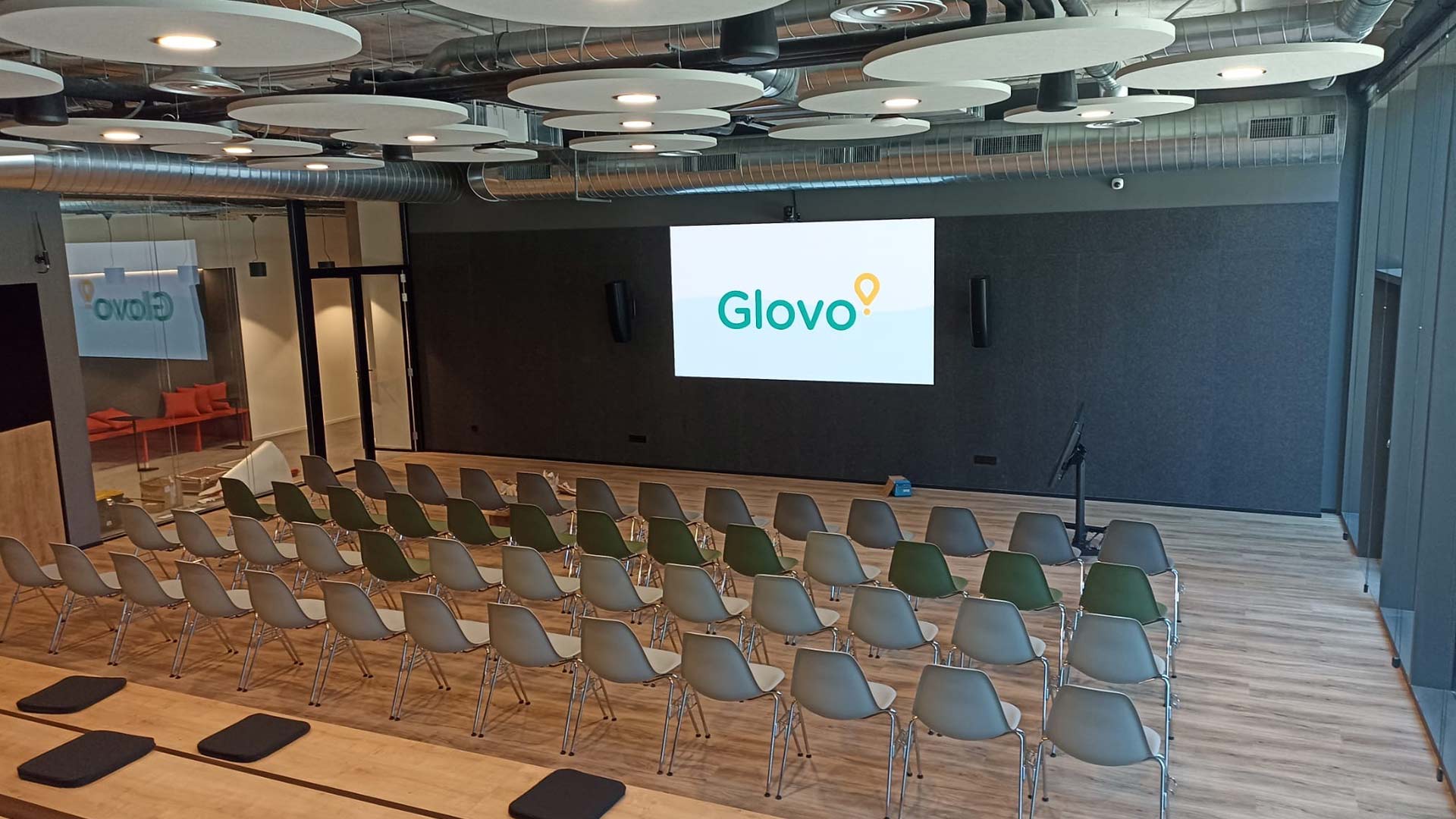 Area di lavoro collaborativo negli uffici di Glovo a Madrid con schermi integrati e sistemi audiovisivi progettati da TRISON