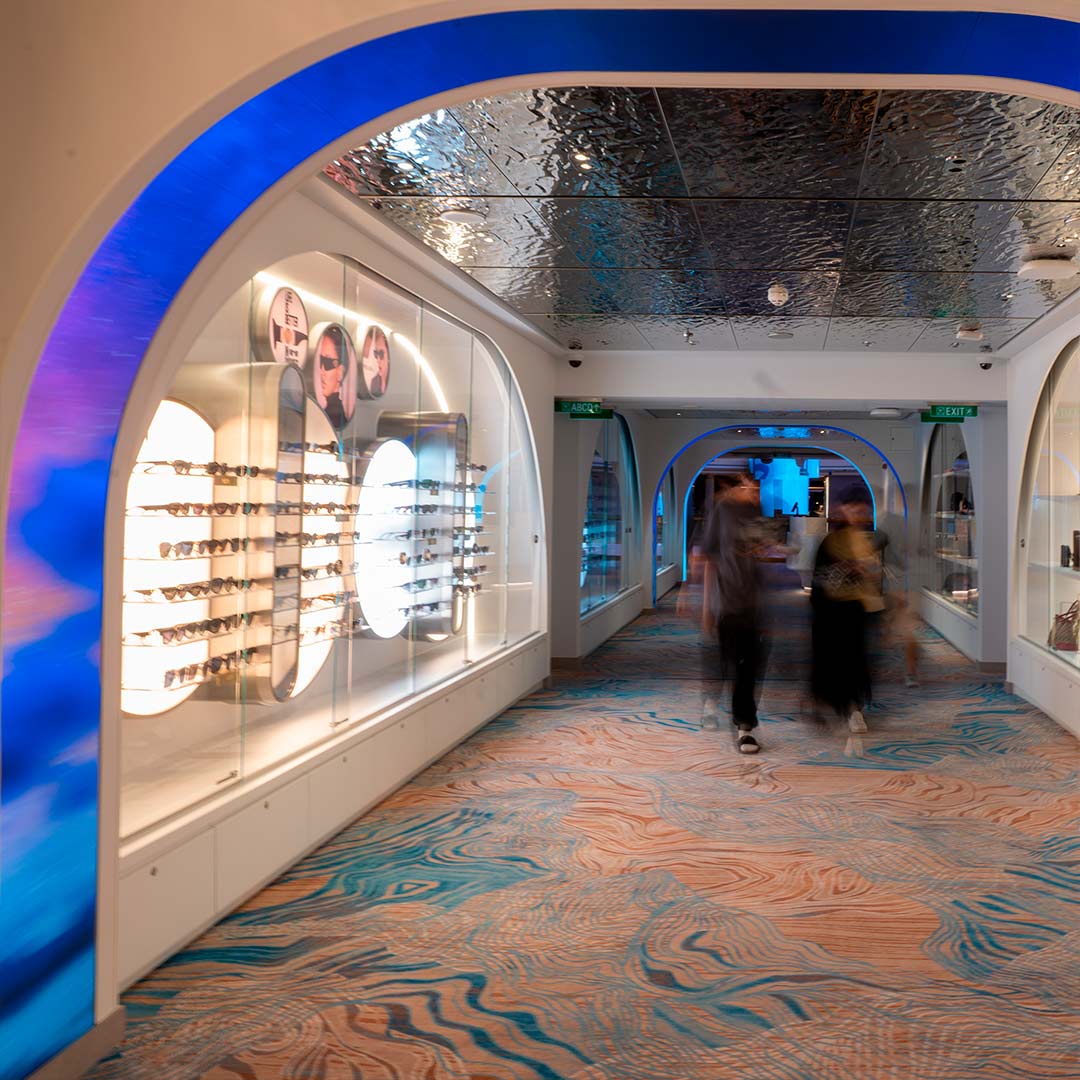 Illuminated retail corridor with arched ceiling and integrated display cases by TRISON Germany on a cruise ship