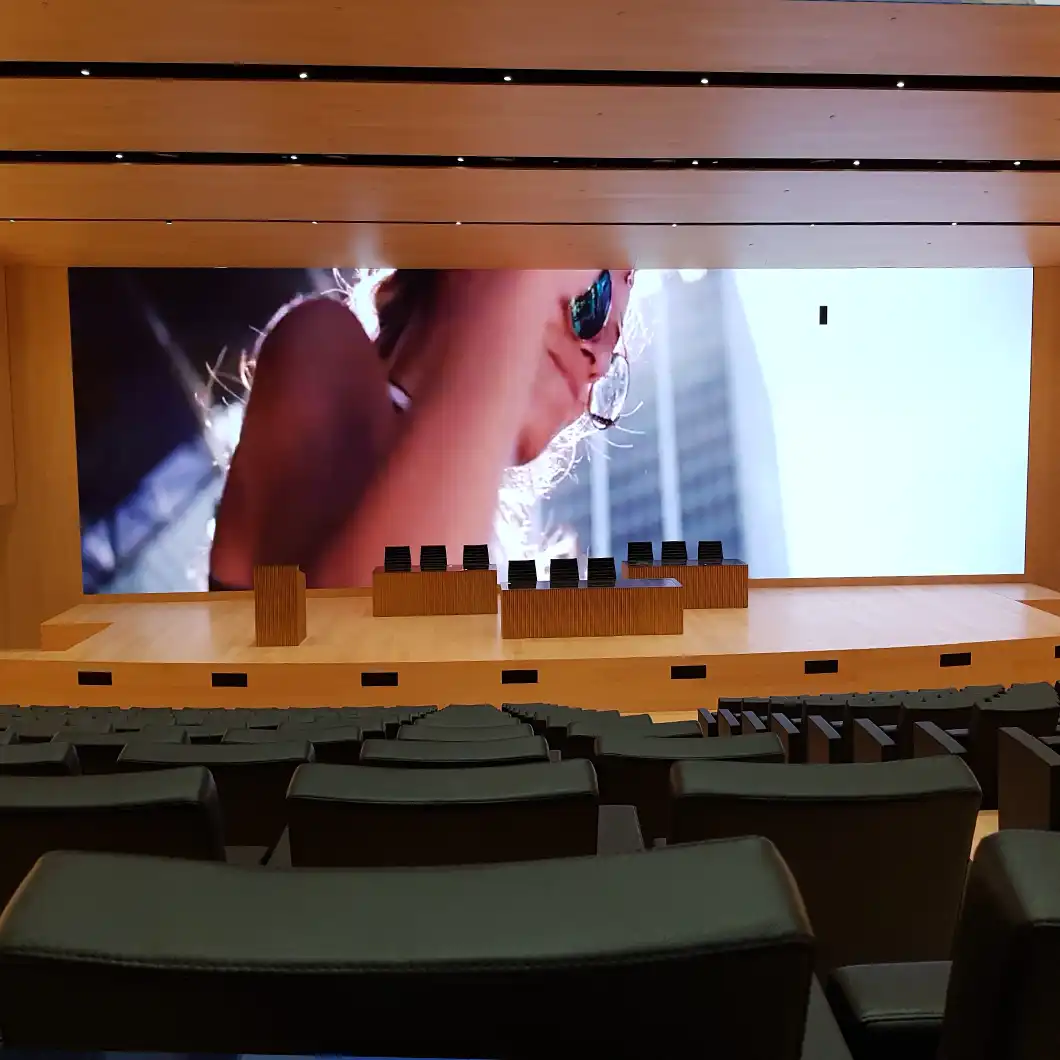 Vista interior del auditorio de Inditex con la enorme pantalla panorámica de LED y la iluminación del escenario.