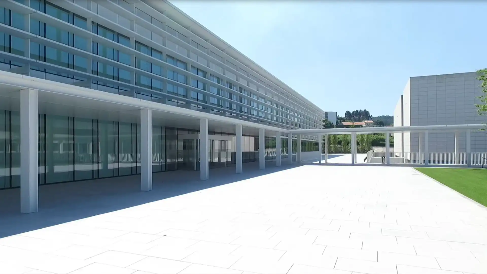 Personas trabajando en el espacio de trabajo abierto de la sede de INDITEX, rodeadas de pantallas digitales y una iluminación arquitectónica integrada.