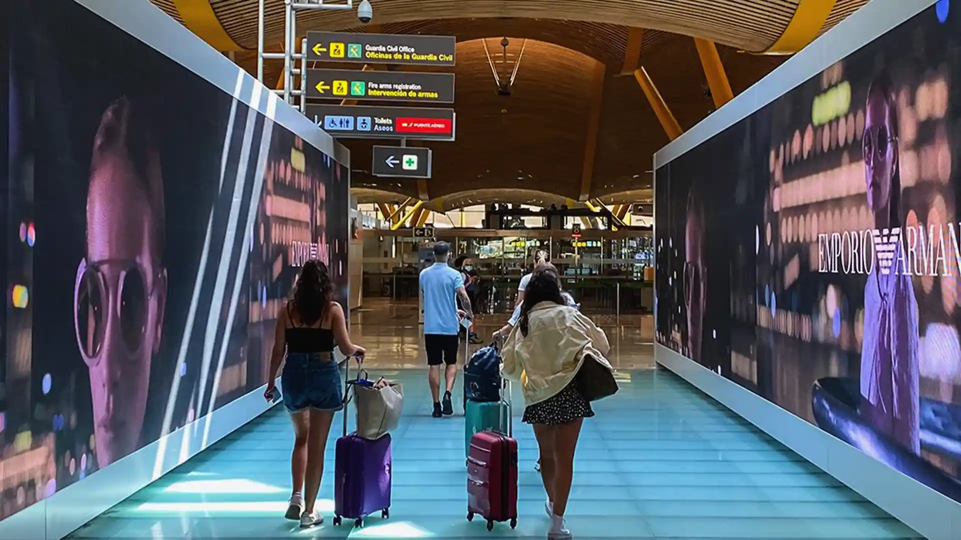Écrans LED le long des passerelles de l'aéroport créant un couloir visuel immersif pour les passagers