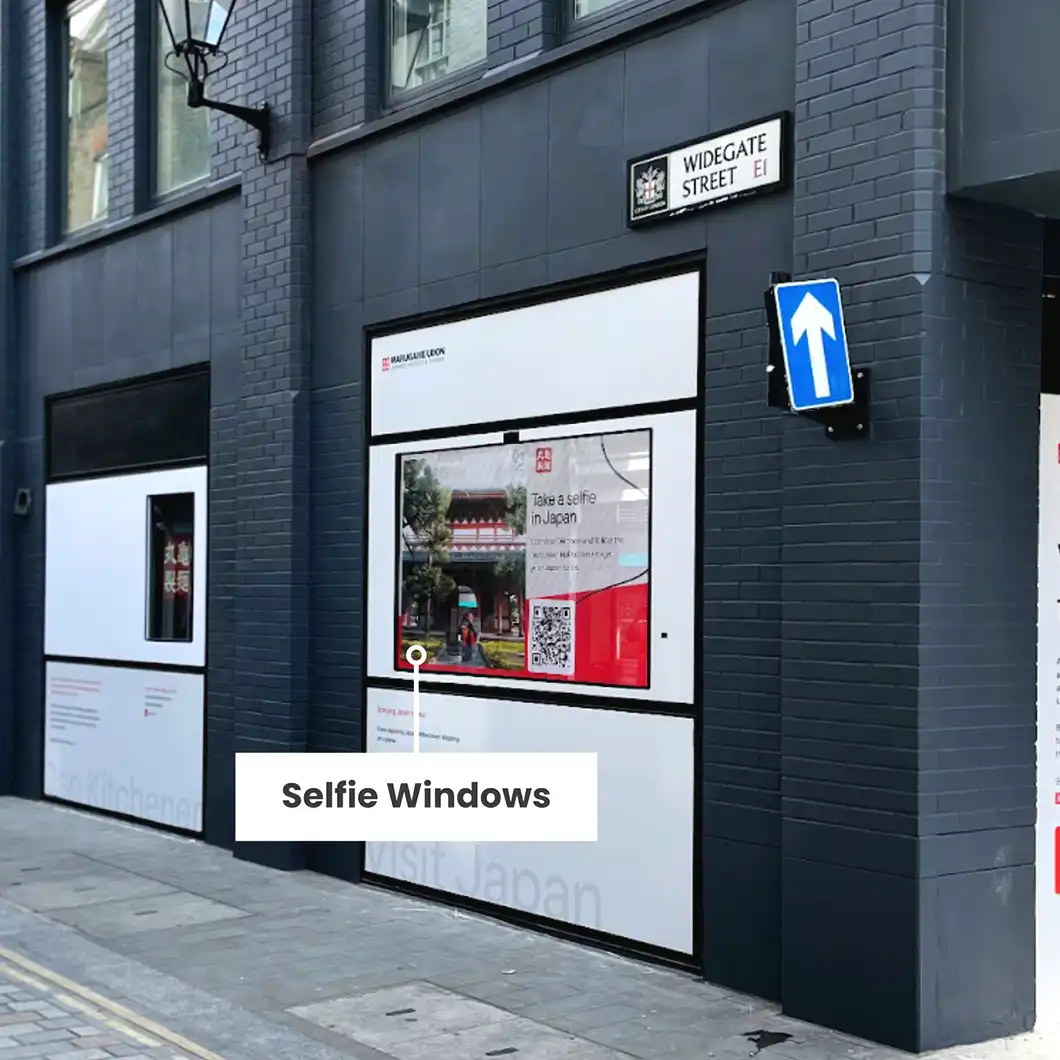 Customer taking a photo at Marugame Udon London’s interactive selfie station with Japanese digital backdrops.