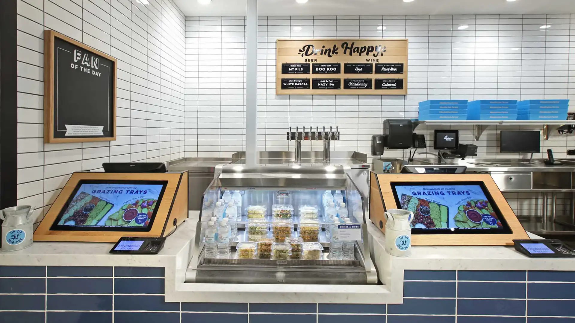 Interaktives digitales Display bei Mendocino Farms, auf dem Kunden Menüoptionen und Informationen zur Nachhaltigkeit entdecken können.