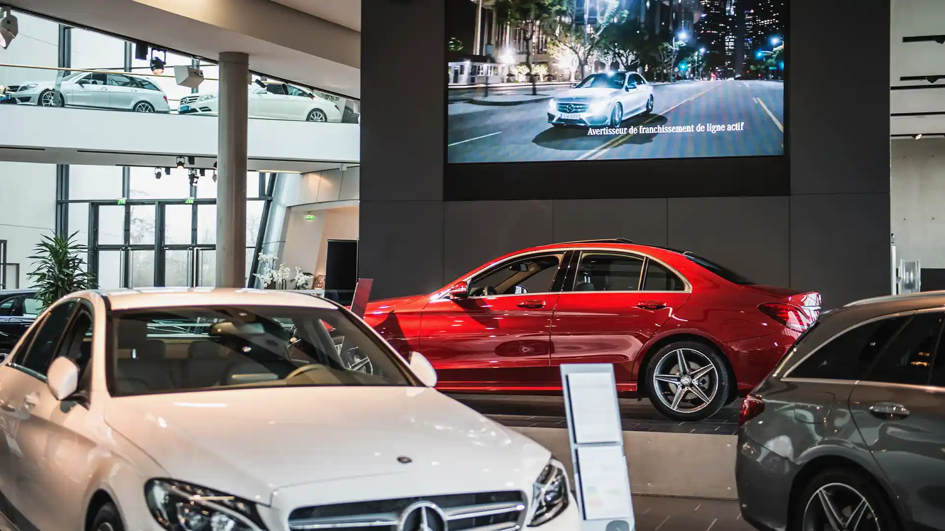 Salle d'exposition Mercedes-Benz à Paris avec un grand écran LED présentant le contenu de la marque par TRISON.