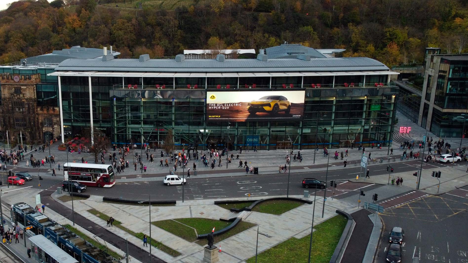 Fachada LED transparente del Omni Centre de Edimburgo iluminada de noche, mostrando un anuncio en movimiento a nivel de calle