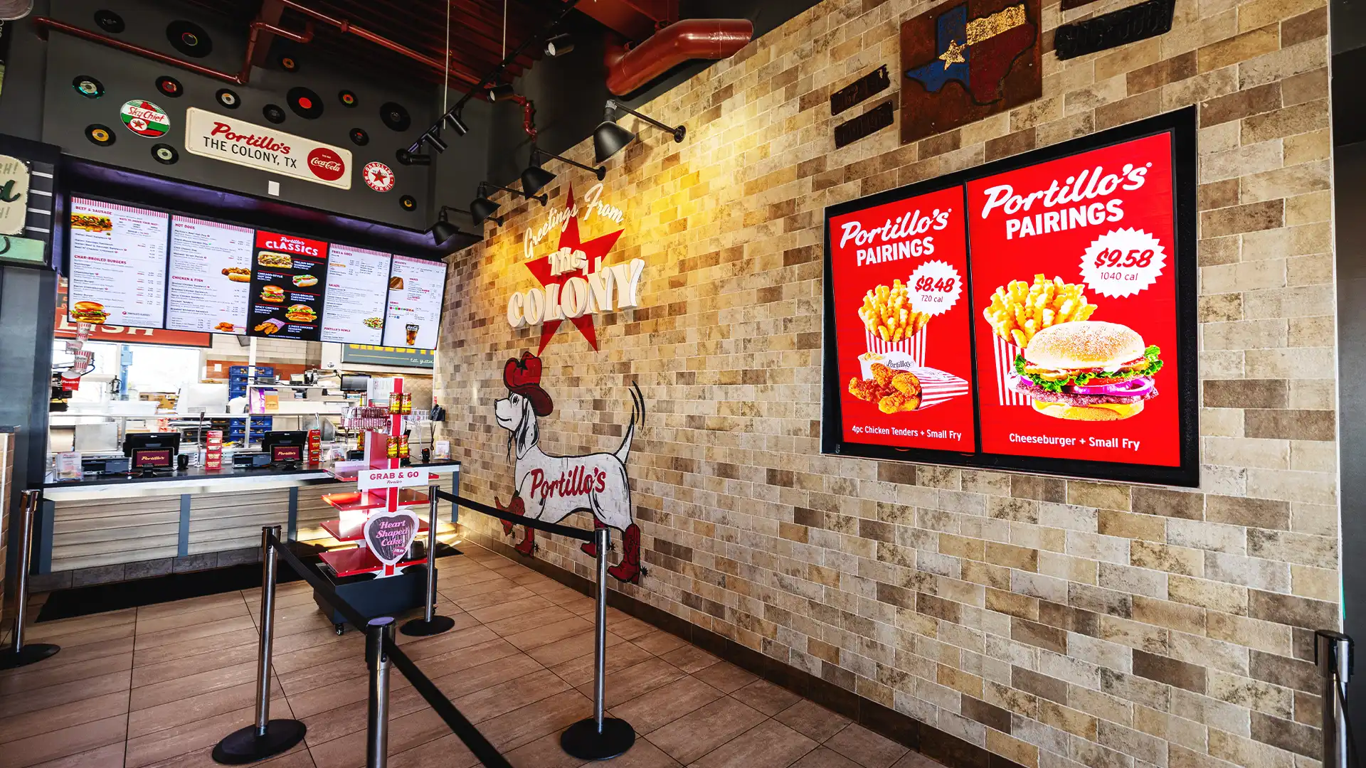 Interno di Portillo's con lavagne menu digitali e display promozionali sincronizzati.