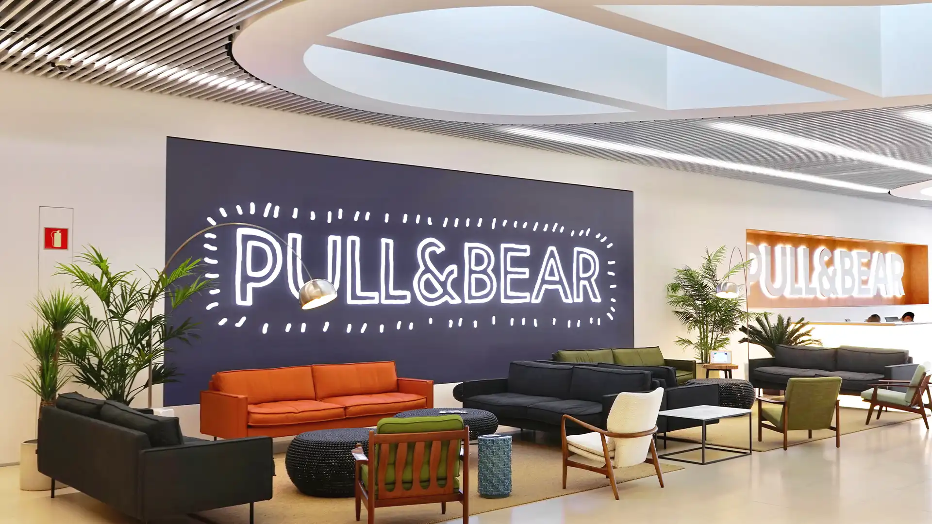 Extérieur du siège de Pull&Bear entouré par la forêt galicienne, montrant l'harmonie entre la nature et l'architecture moderne.