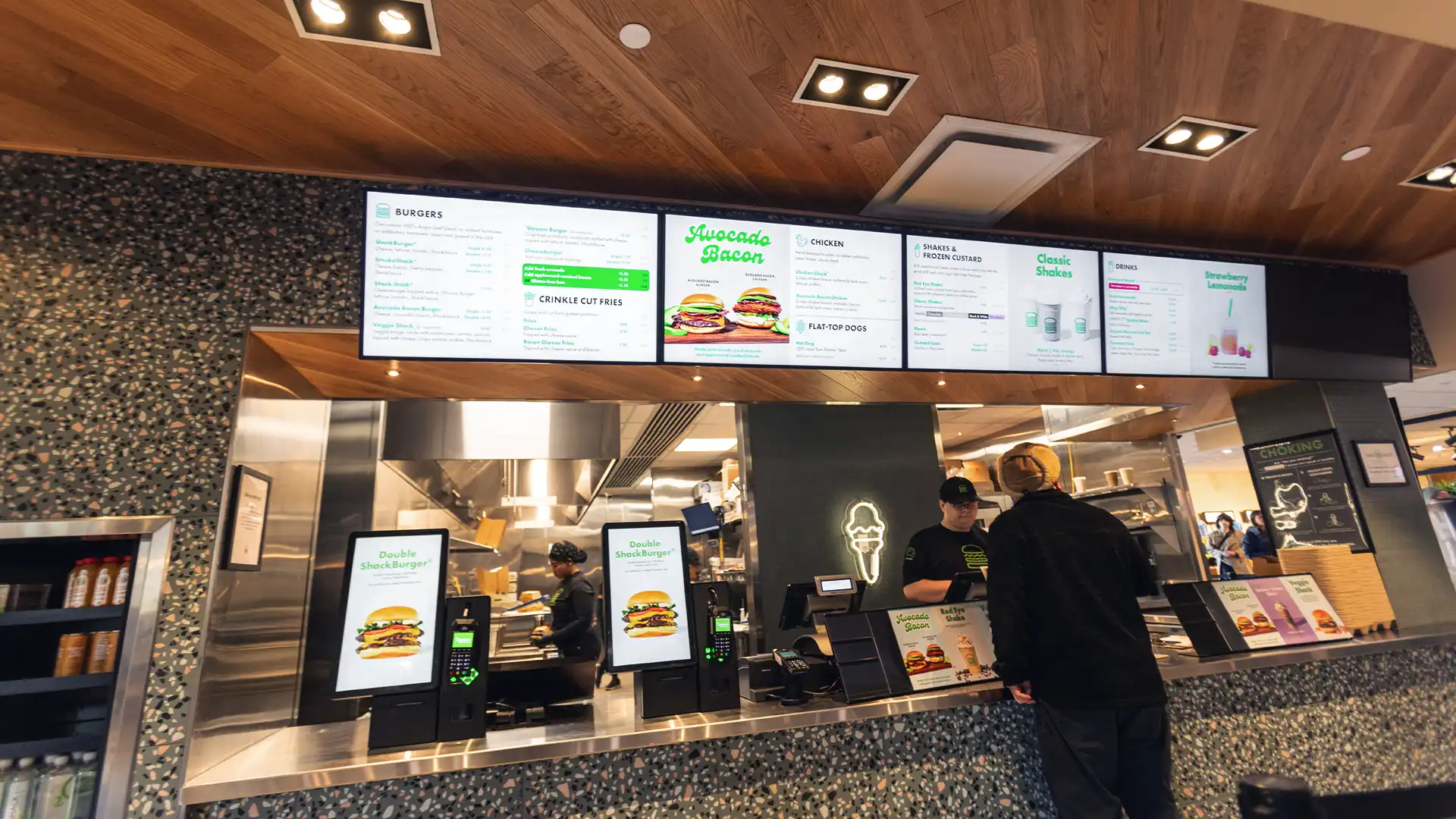 Display digitale per le code del ristorante Shake Shack che mostra lo stato degli ordini in tempo reale, migliorando l'efficienza operativa.