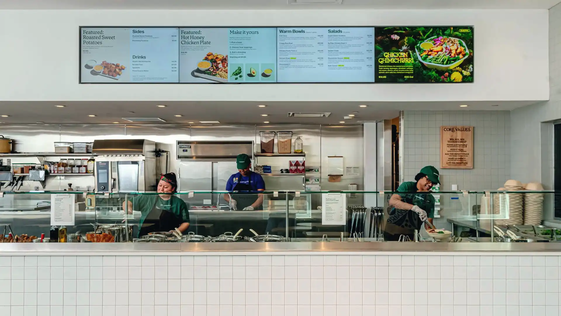 Interaktives digitales Display im Sweetgreen Restaurant, das saisonale Produkte und die Herkunft der Zutaten anzeigt.