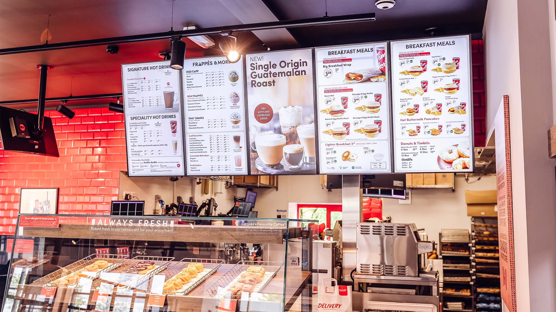 Pared de menús digitales en restaurante Tim Hortons UK mostrando bebidas y desayunos en pantallas instaladas por TRISON