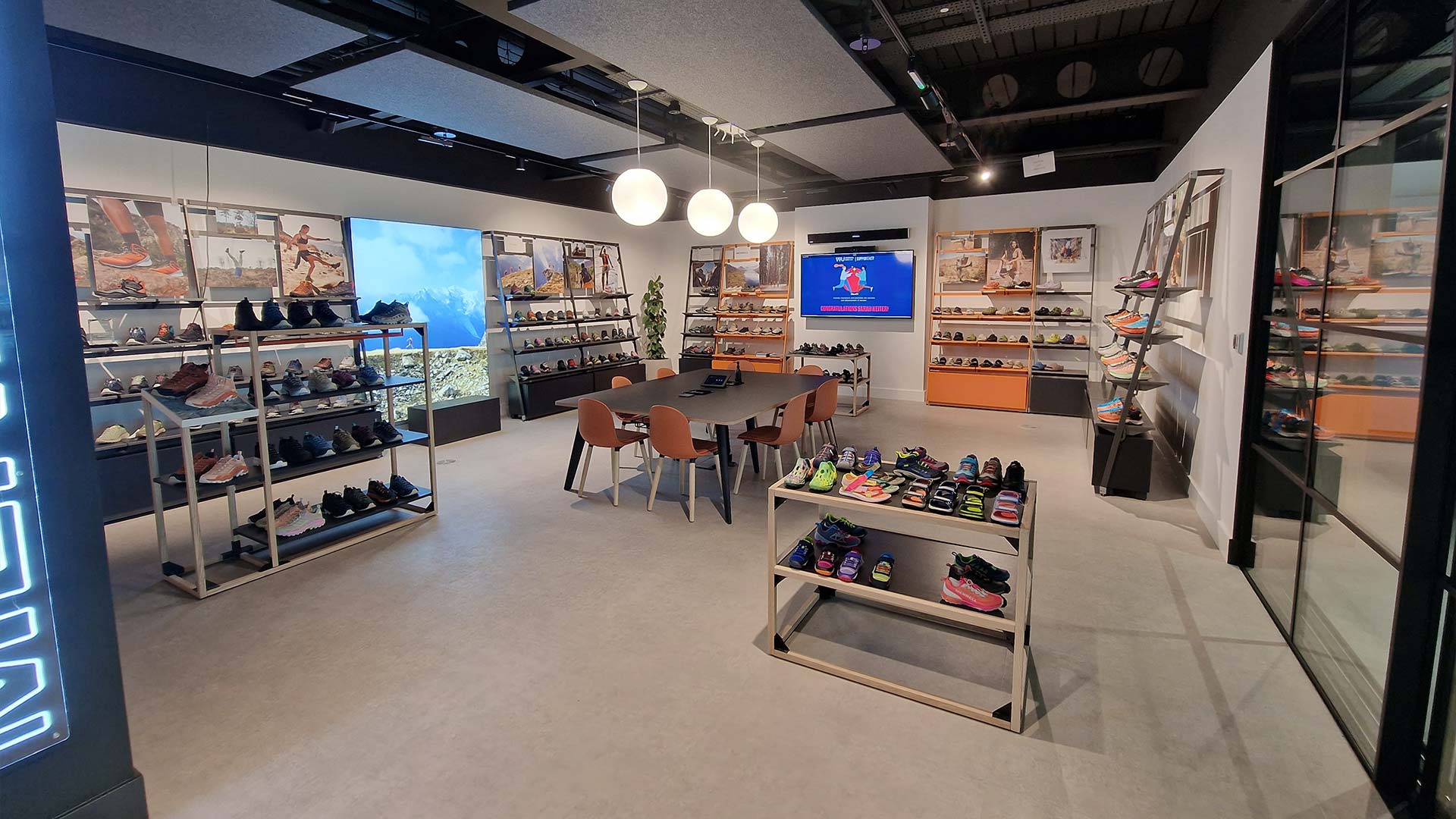 Showroom de la marca Merrell en la sede de Wolverine Worldwide en Londres con pantalla de gran formato y estanterías de producto